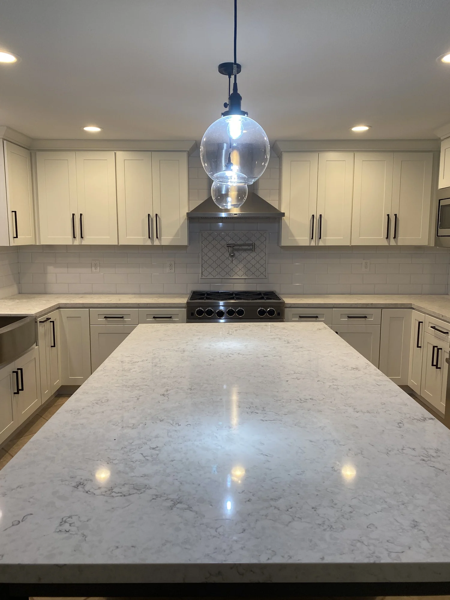 Modern kitchen with waterfall-edge island by JBC Design & Build